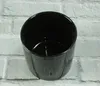 A black ceramic pot on a light gray brick-like background. Produktbild-Vorschau