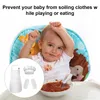 A baby wearing a bib and a chef's hat is sitting in a high chair and eating. Produktbild-Vorschau