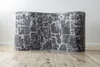 A curved rug with a stone pattern is placed on a wooden floor against a white wall. Produktbild-Vorschau