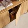A close-up view of a wooden sideboard with two doors open, revealing shelves and decorative items inside. Produktbild-Vorschau