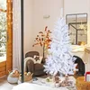 A white artificial Christmas tree is set up in a cozy living room with a fireplace and armchair. Voir les images du produit