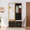 A hallway furniture set with a mirror, coat rack, bench, and storage drawers, placed in a room with a door and wall art. Produktbild-Vorschau