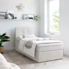 A bedroom scene with a bed, shelf, and plant.