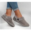 A pair of women's gray slippers with faux fur trim, worn with cuffed blue jeans. Produktbild-Vorschau