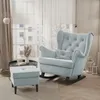 A light blue upholstered rocking chair with an ottoman in a well-lit room with a large window and sheer curtains. Voir les images du produit