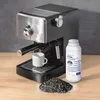 An espresso machine with a coffee cup, a bottle of filter granules, and a pile of filter granules on a wooden surface. Náhľad obrázku produktu