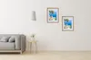 A living room scene with a sofa, a side table with a plant, and two framed pictures on the wall. Produktbild-Vorschau