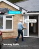 An elderly man carries a box towards a house with a security camera visible. Produktbild-Vorschau