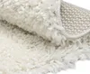 A close-up view of a fluffy white rug, showing its texture and the underside of the rug. Náhľad obrázku produktu