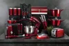 A collection of red kitchen appliances and cookware arranged on a dark surface against a textured gray background. Voir les images du produit