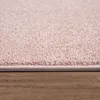 A close-up view of the edge of a pink rug on a wooden floor. Produktbild-Vorschau