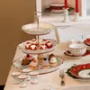 A tiered cake stand filled with festive cupcakes and strawberries, set on a table with other holiday-themed tableware. Anteprima dell’immagine prodotto