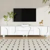 A white TV stand with a minimalist design is shown in a living room setting, with a TV mounted on the wall above it. Podgląd zdjęcia produktu