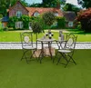 A garden scene with a house, lawn, and outdoor furniture. Produktbild-Vorschau