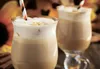 Two glasses of cappuccino with foam and straws, with pumpkins and autumn leaves in the background. Produktbild-Vorschau