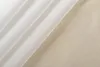 A white sheer curtain is draped diagonally across a light wood surface. Produktbild-Vorschau