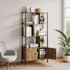 A bookshelf with various items on it, placed next to a chair and a plant in a room. Produktbild-Vorschau