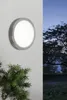 A wall-mounted outdoor light fixture is shown on a white wall, with a dark tree and sky in the background. Podgląd zdjęcia produktu