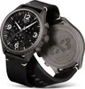 A Tissot chronograph watch with a black dial and black leather strap, shown from a diagonal angle. The back of the watch case is also visible, showing engravings. Produktbild-Vorschau