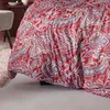 A close-up view of a red comforter with a paisley pattern. Produktbild-Vorschau