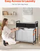 A woman is shown interacting with a laundry sorter in a room with shelves. Náhled obrázku produktu