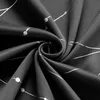 A close-up, swirled view of black fabric with a white geometric pattern. Produktbild-Vorschau