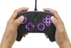 Hands holding a black Nintendo Switch controller with purple LED lighting. Voir les images du produit