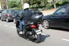 A person riding a scooter in traffic. Anteprima dell’immagine prodotto