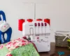 A sewing machine with spools of thread, a quilted fabric, and a stuffed cat toy. Náhled obrázku produktu