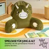 A plush dinosaur pillow is placed on a colorful rug in a child's room, with an open book in front of it. Podgląd zdjęcia produktu