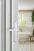 A bathroom scene viewed through an open door, showing a bathtub, window, and floor tiles. Produktbild-Vorschau