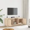 A wooden TV stand with open compartments and doors, placed against a white wall with a TV mounted above it. Produktbild-Vorschau