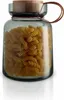 A glass storage jar filled with fusilli pasta, with a wooden lid and a copper-colored handle. Voir les images du produit