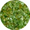 A close-up view of small, irregular pieces of green and yellow glass or filter material. Produktbild-Vorschau