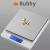 A digital scale with two gold rings on it. Produktbild-Vorschau
