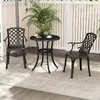 A patio set with two chairs and a table on a rug on a deck, with a white lattice fence and plants in the background. Podgląd zdjęcia produktu