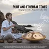 A man playing a handpan drum on a rocky beach by the sea. Náhled obrázku produktu