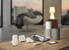 A collection of smart home devices arranged on a wooden table in a living room setting. Produktbild-Vorschau