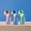 Three children's water bottles with straws are lined up against a blue background. Voir les images du produit