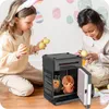 Two young girls are playing with a toy safe, putting Easter eggs into it. The background is decorated with Easter eggs. Náhled obrázku produktu