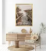 A framed picture of a wooden staircase leading to a beach is displayed above a wooden sideboard with decorative items. Voir les images du produit