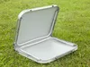 An open, silver-colored folding table is placed on a grassy lawn. Anteprima dell’immagine prodotto