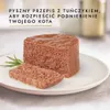 A close-up of a portion of cat food on a white plate, with a sprig of rosemary. Text is overlaid at the top of the image. Podgląd zdjęcia produktu
