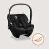A black baby car seat is shown against a light beige background, with a small circular graphic of a feather in the lower right corner. Produktbild-Vorschau