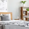 A bedroom scene with a bed, nightstand, and bookshelf. Produktbild-Vorschau