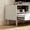 A close-up view of a white TV cabinet with a drawer partially open, showing electronic devices inside. Produktbild-Vorschau