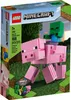 The image shows the front of a LEGO Minecraft building toy box, featuring a large pink pig with a baby zombie riding on its back, set against a backdrop of grass and trees. Podgląd zdjęcia produktu