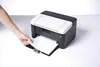 A hand is inserting paper into a black and white Brother laser printer. Náhľad obrázku produktu