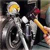 A person is using a hammer to adjust a dial indicator on a piece of machinery. Náhľad obrázku produktu