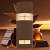 A perfume bottle is surrounded by chocolate, tobacco leaves, and a small jar of honey, suggesting the fragrance notes. Voir les images du produit